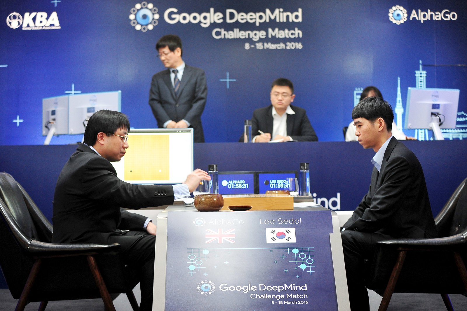 人工智能系統 AlphaGo 與棋手李世石首次對戰，研發團隊成員兼業餘棋手黃士傑（右）替 AlphaGo 走棋。 圖片來源：路透社