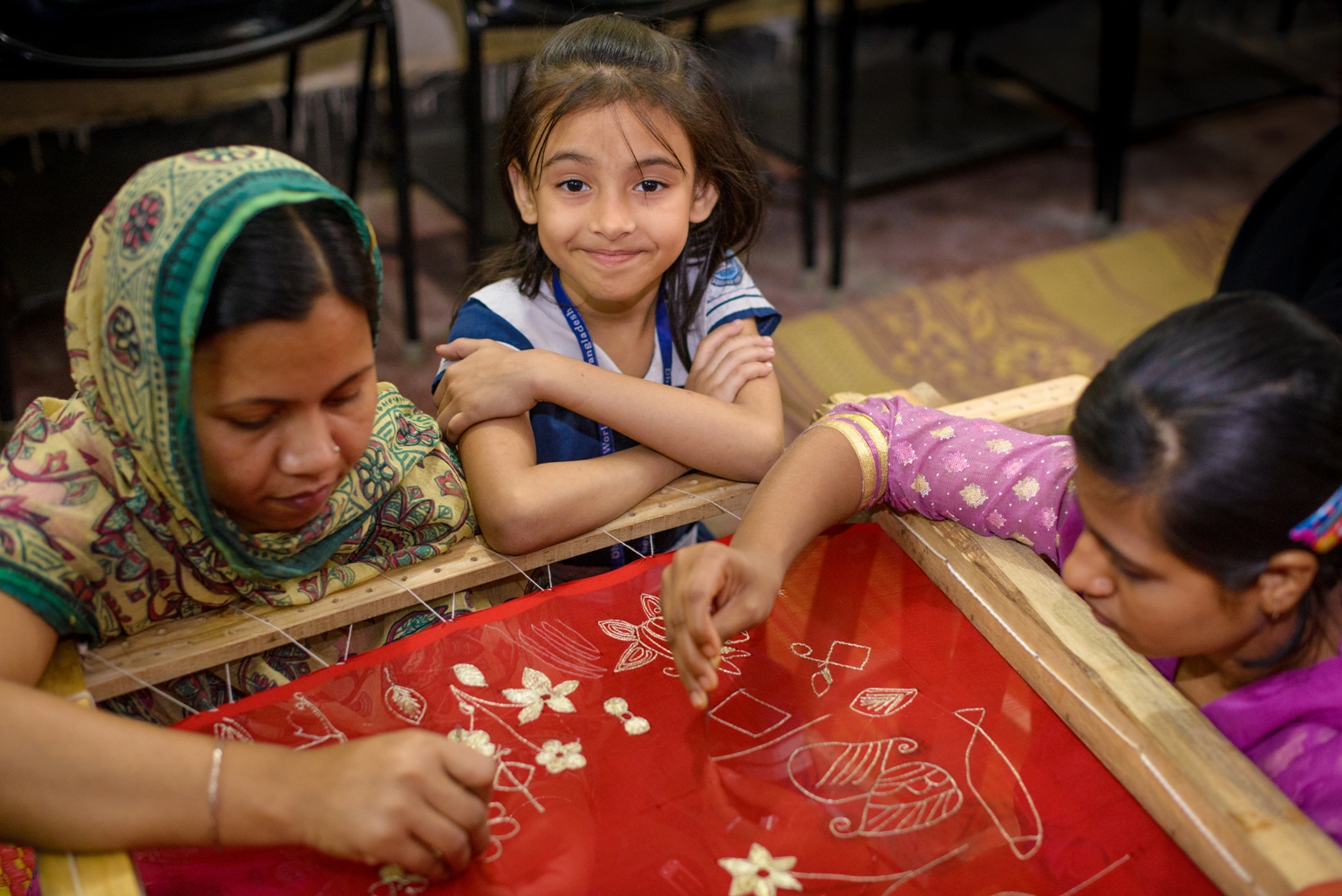 素美雅（中）和母親泰絲利瑪（左）在宣明會開設的社區中心學習孟加拉傳統刺繡技巧。