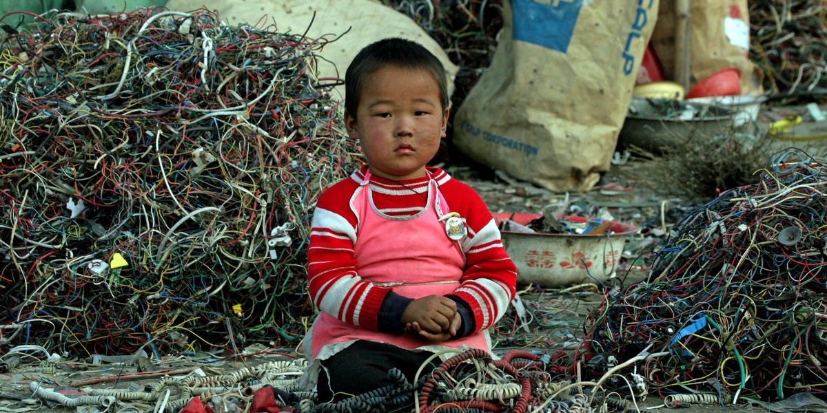 有拾荒兒童在被重金屬化學污染的電子垃圾場中尋有價值的零件。