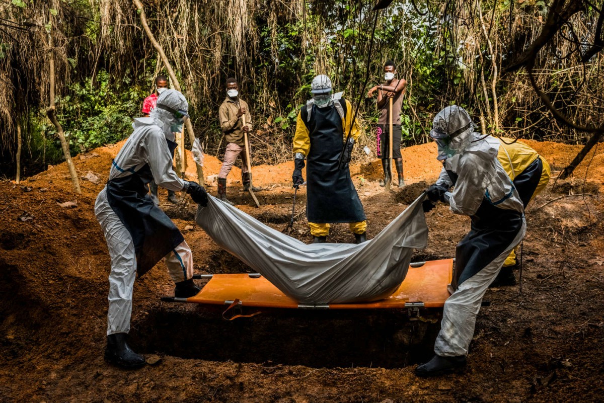 2014 年 10 月，利比里亞防疫人員正埋葬一名懷疑感染伊波拉病毒的死者。　圖片來源：紐約時報