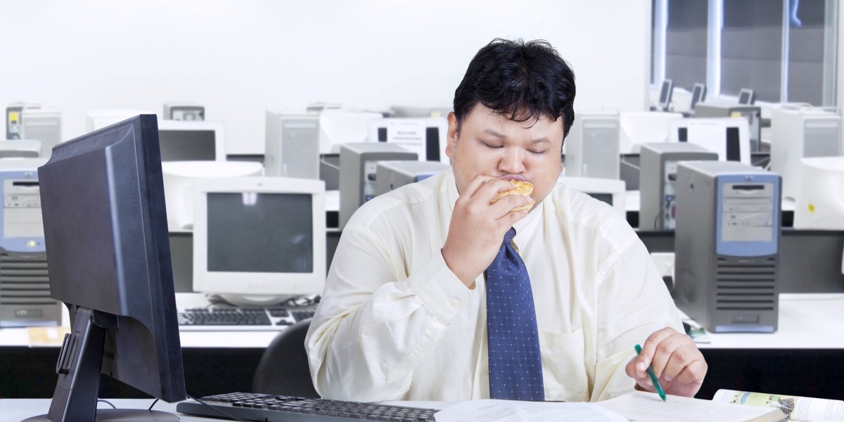 Entrepreneur working while biting burger