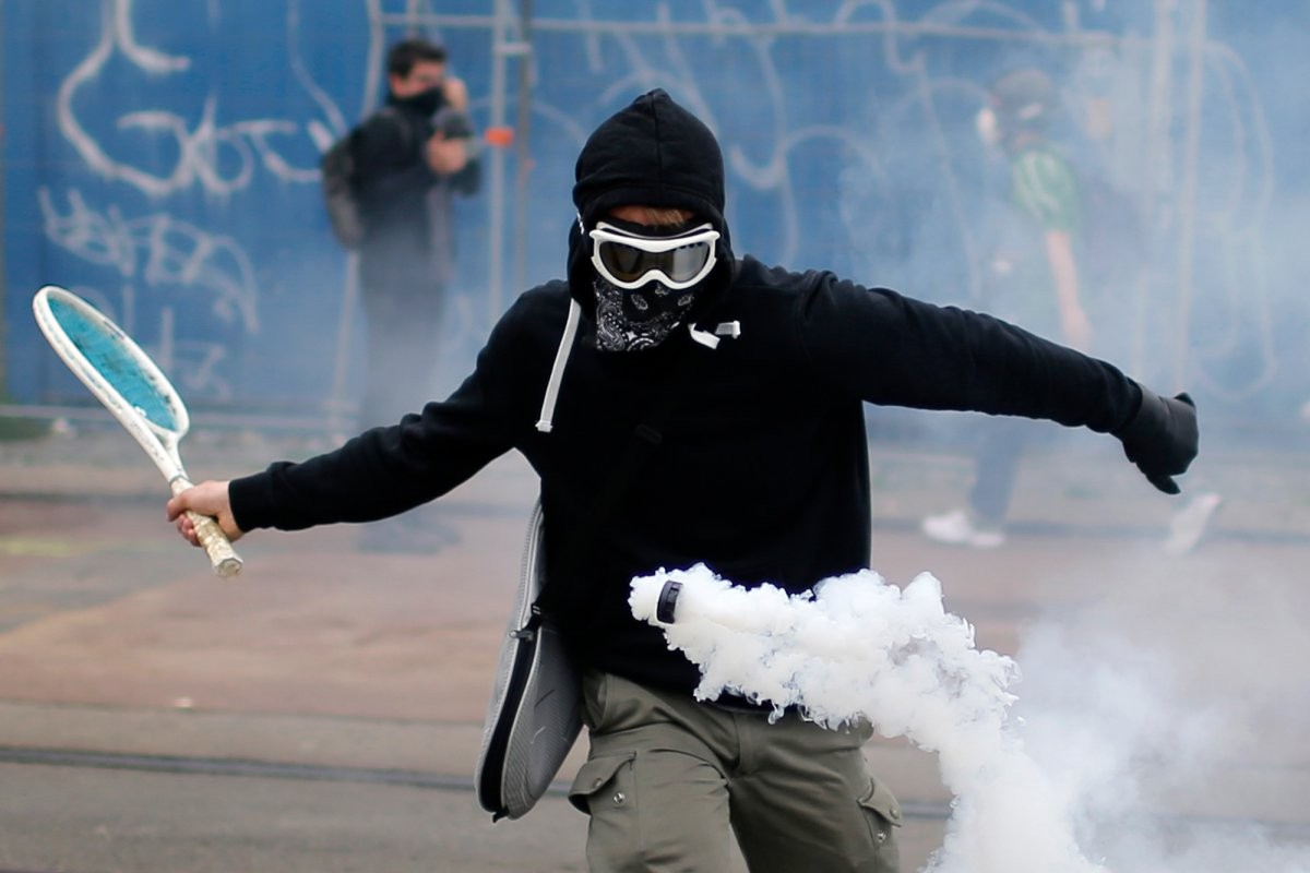 a-protestor-uses-a-tennis-racket-to-bounce-a-tear-gas-canister-during-a-demonstration