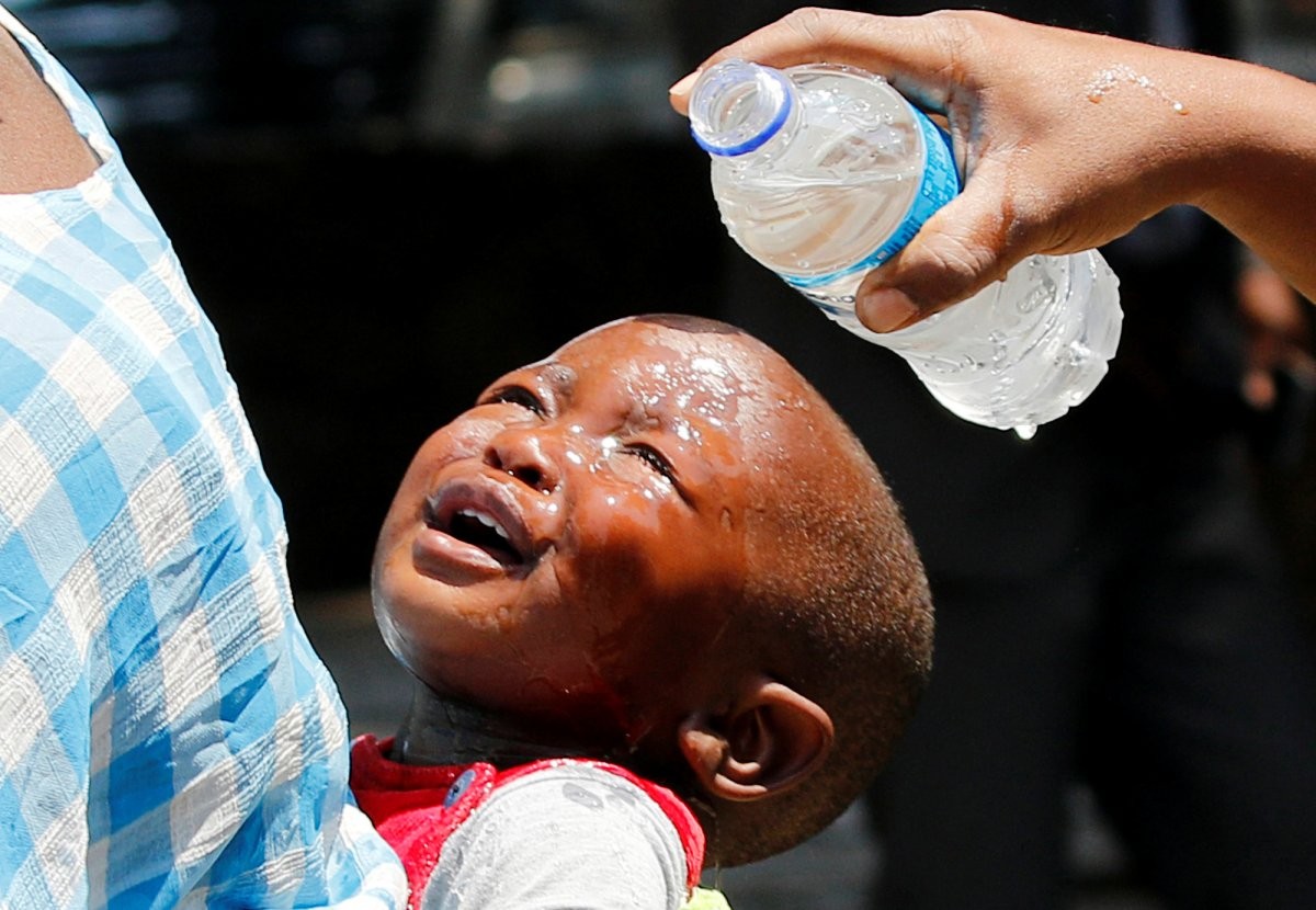 a-woman-pours-water-over-a-child-affected-by-teargas-after