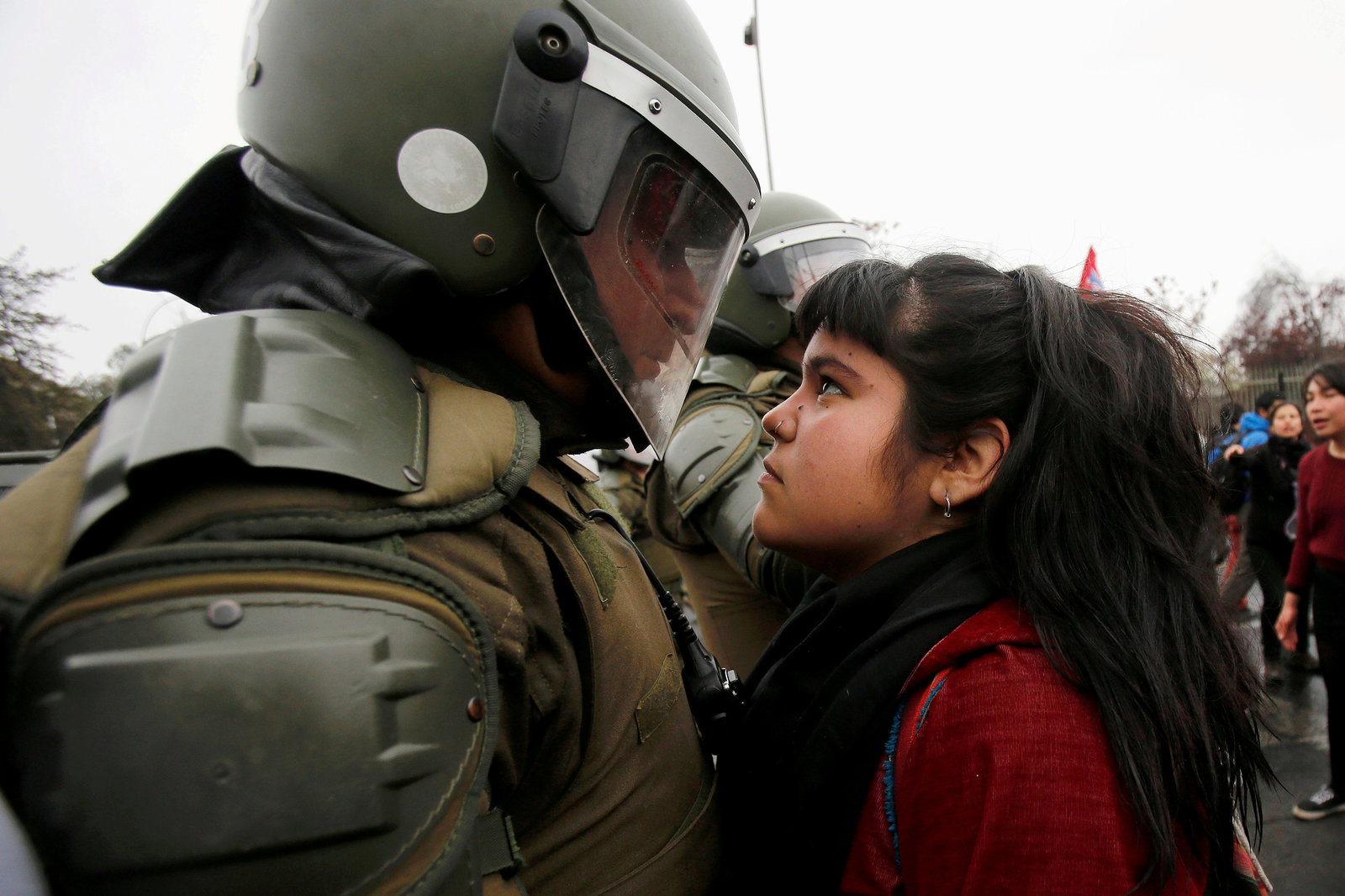 9 月 11 日，智利舉行軍事政變 43 週年紀念遊行，一名示威者緊盯著防暴警察。