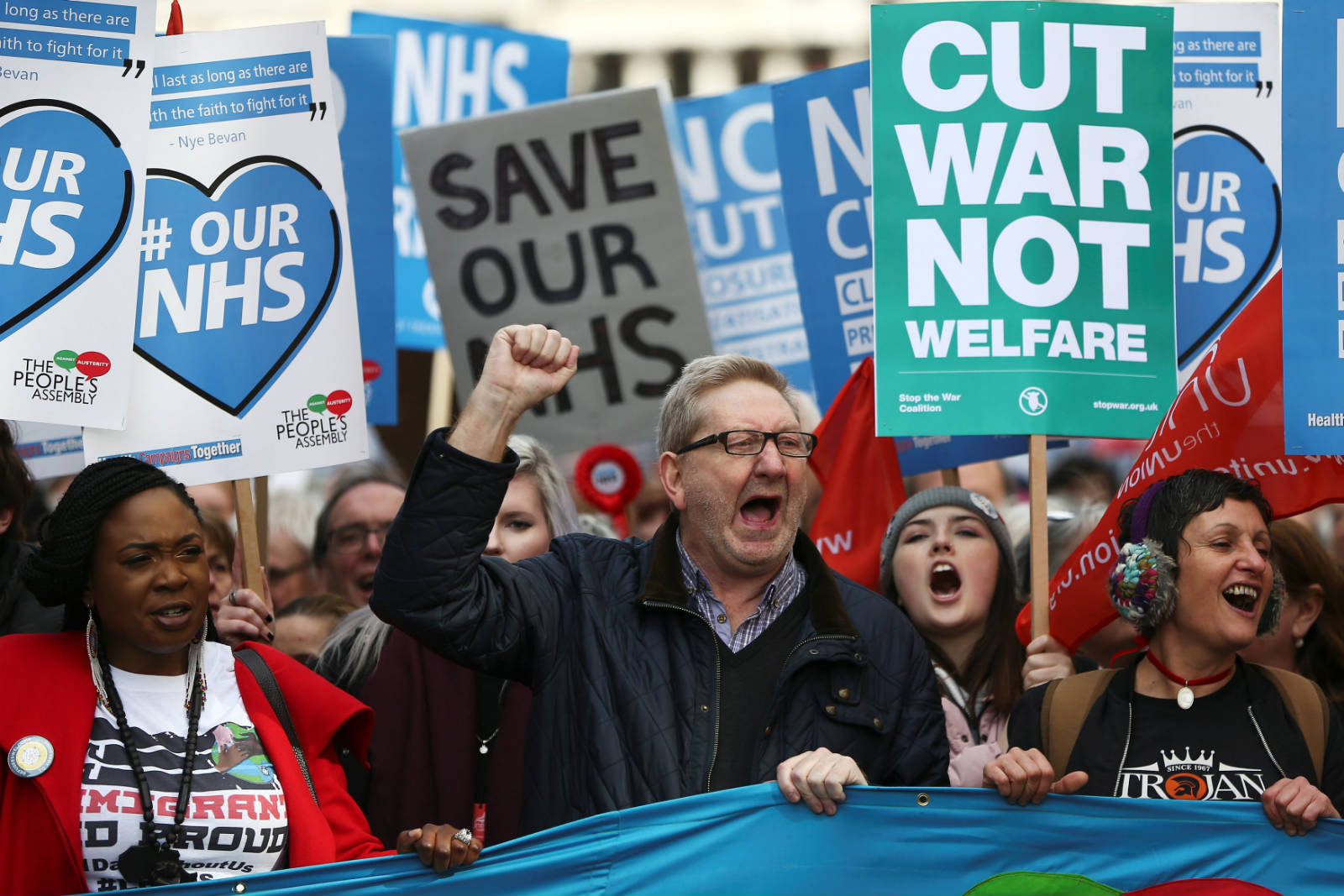 英國示威人士高舉「Cut War Not Welfare」的牌表達訴求。　圖片來源：路透社