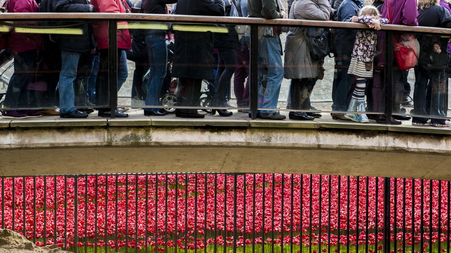2014 年 11 月 08 日，人們在倫敦塔排隊觀賞紅色罌粟花的裝置藝術。該次陶瓷罌粟花的藝術裝置是為紀念第一次世界大戰爆發百週年。（圖片來源：Shutterstock）