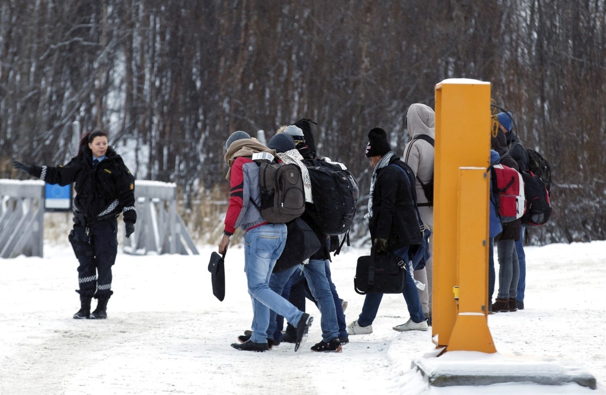 一名挪威警員向一批剛穿越邊境的難民發出指示。圖片來源：路透社