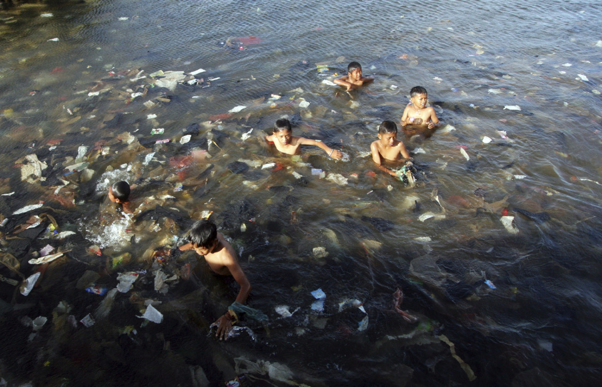 印度尼西亞雅加達北一處海灘，兒童與廢膠「暢泳」，膠災嚴重
