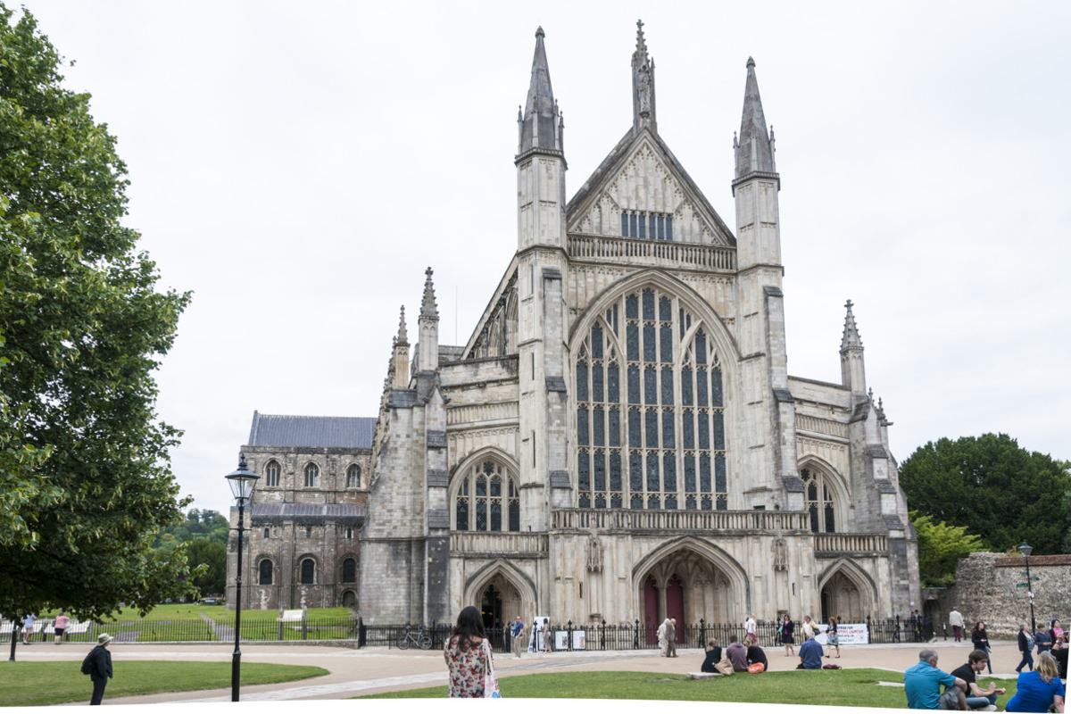 Winchester, United Kingdom - August 11, 2015: Tourists and pedestrians walking around Winchester Cathedral grounds.