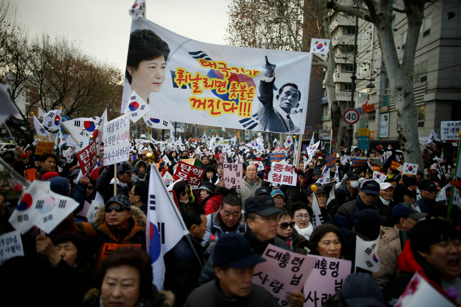 朴槿惠支持者高舉印有朴與其父親朴正熙頭像的橫額。　圖片來源：路透社