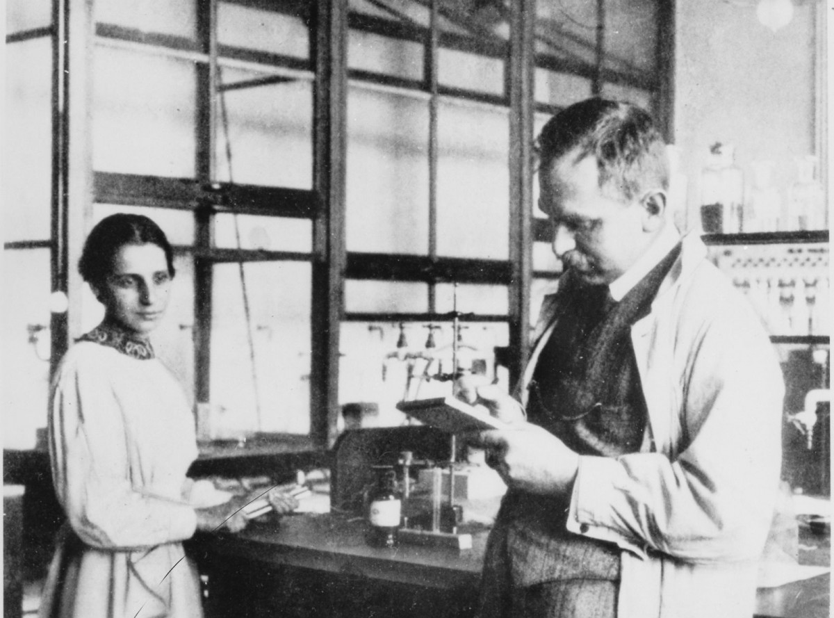 Lise Meitner （左）與 Otto Hahn （右）。Meitner 出生於猶太家庭，與哈恩共事 30 多年，於1938 年（即發現鈾分裂同年）逃離德國，她在發現核裂變的貢獻被當時諾貝爾獎委員會所忽略。　圖片來源：wikimedia